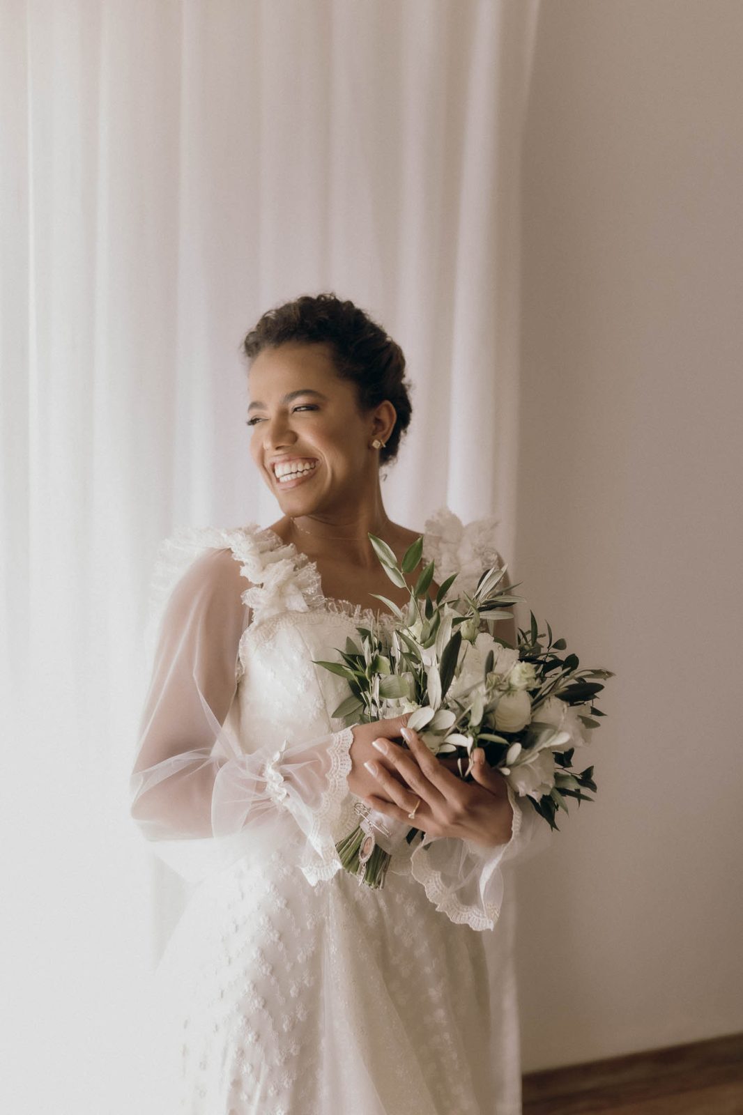 bride wearing a long sleeved boho dress with tule and lace