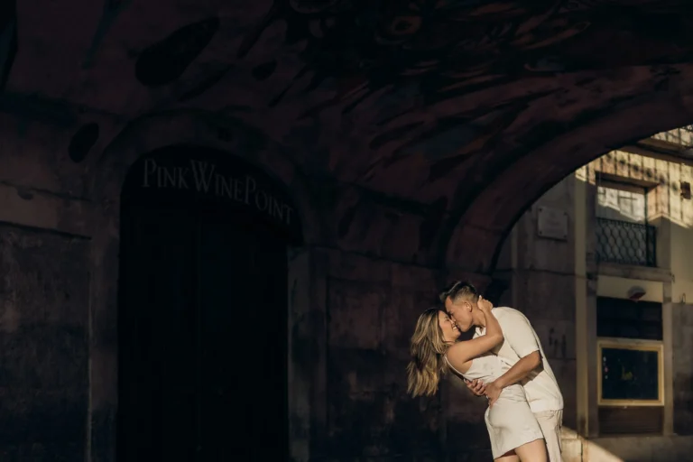 couple kissing on pink street in lisbon